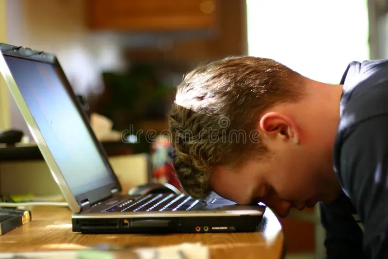 Man feeling burnt out resting his head on a laptop